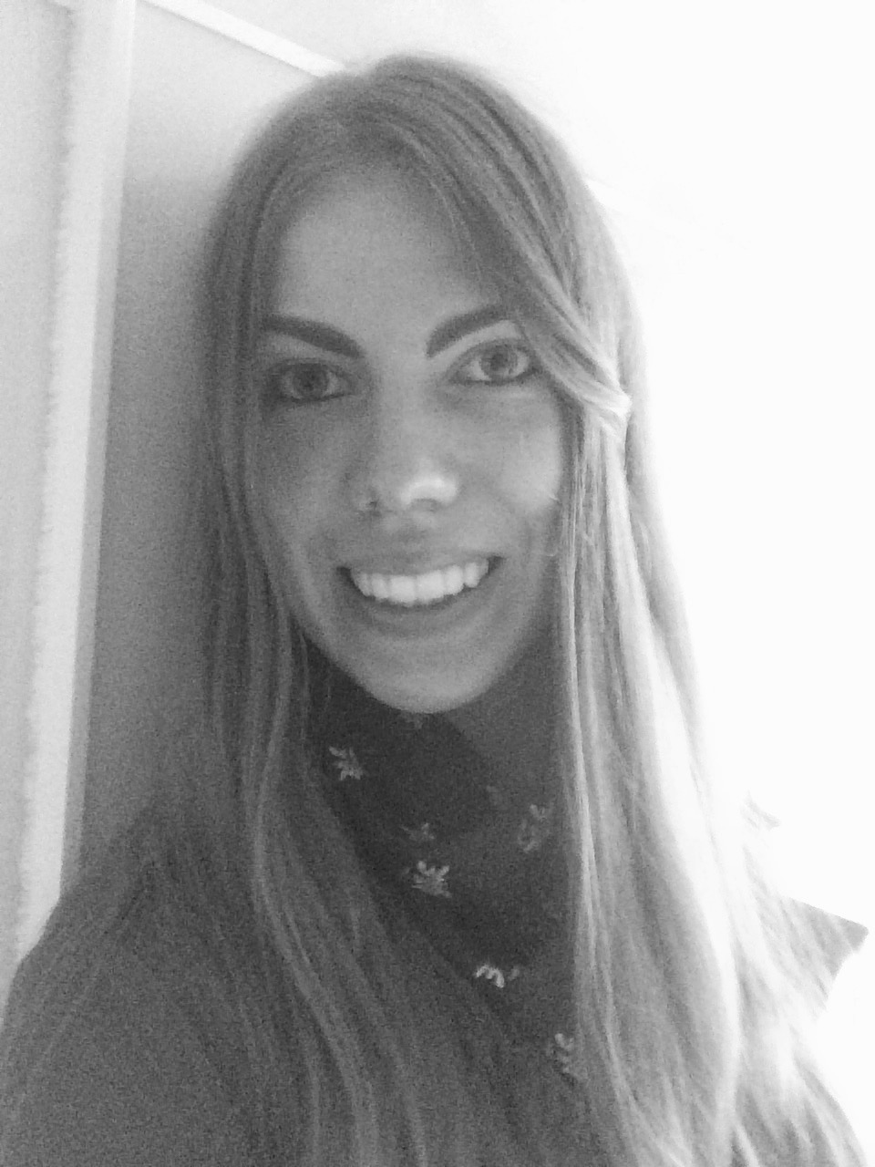 Heidi Hassinen hymyilee kameralle mustavalkoisessa kuvassa.