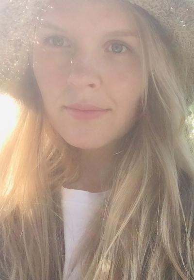 Tuuli Kainulainen hymyilee selfiessä kesäauringossa.