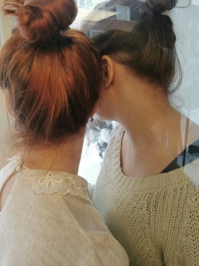 Kaksi henkilöä lasin eri puolilla.